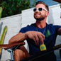Man sitting on a bicycle holding a 'sip' bottle with a blurred background